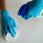 person in blue gloves holding white textile